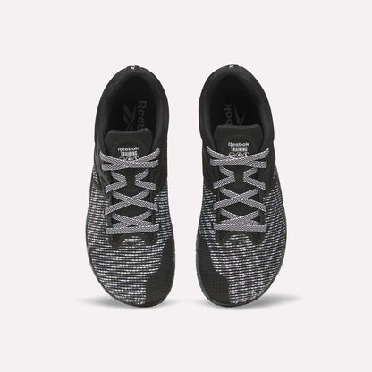 Top view of a pair of Reebok Nano Zero Training Shoes in black with white and gray patterned laces and mesh uppers, ideal for strength training, displayed side by side on a plain white background.