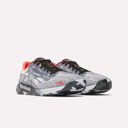 The Reebok Nano Pro Training Shoes feature a gray mesh upper, black laces, white and black patterned soles, red accents, and visible Reebok logos—ideal for competitive athletes.