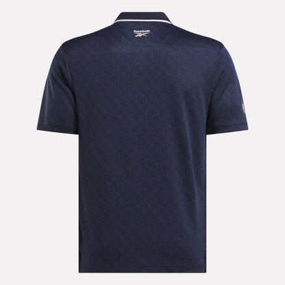 Back view of the Men's BDC Signature Polo Shirt by Reebok in navy blue, featuring RBK-DRY fabric, a subtle textured pattern, a collar, and the Reebok logo below the neckline.