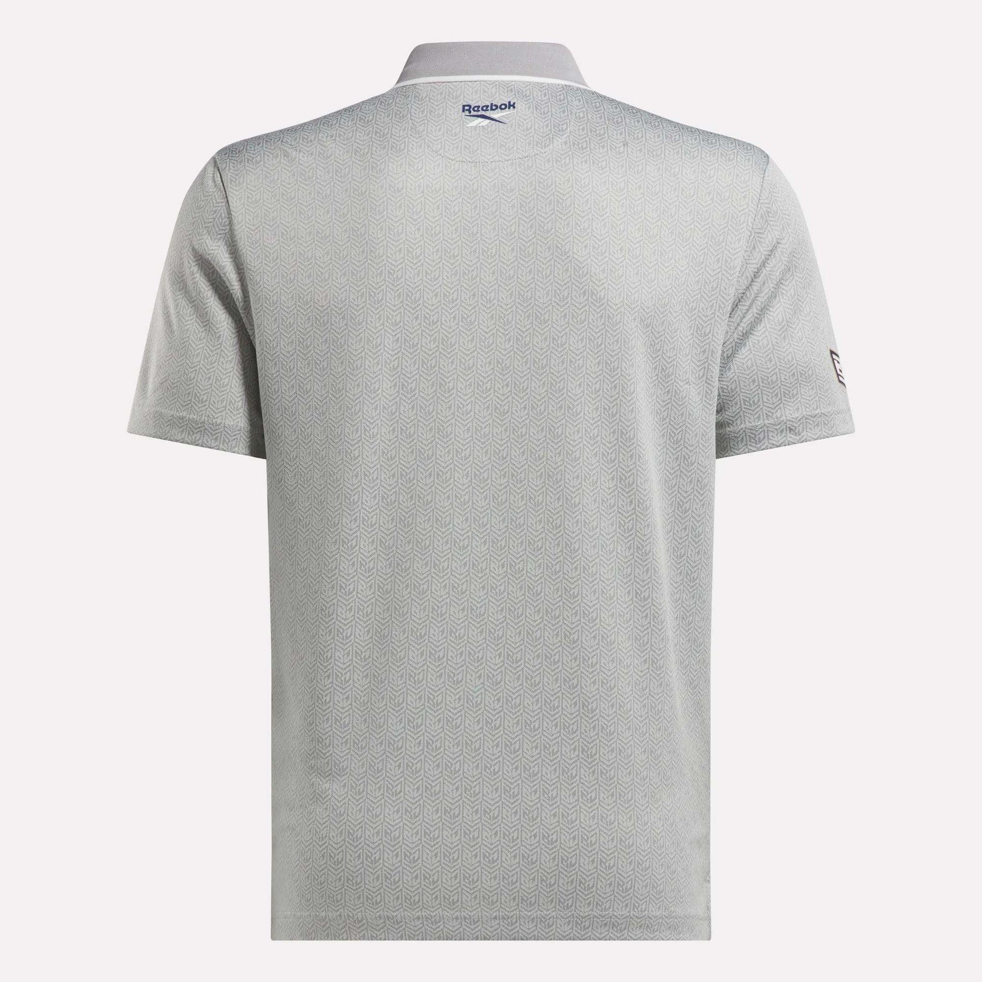 Back view of the Men's BDC Signature Polo Shirt by Reebok in light gray, featuring short sleeves, a subtle geometric pattern, and logos near the collar and left sleeve. Made with RBK-DRY fabric for comfort on and off the course.