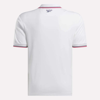 The Reebok Men's Country Club Oxford Pique Polo Shirt in white is shown from the back, featuring thin red and black stripes on the sleeve cuffs and a small Reebok logo near the collar for a stylish, sporty accent.