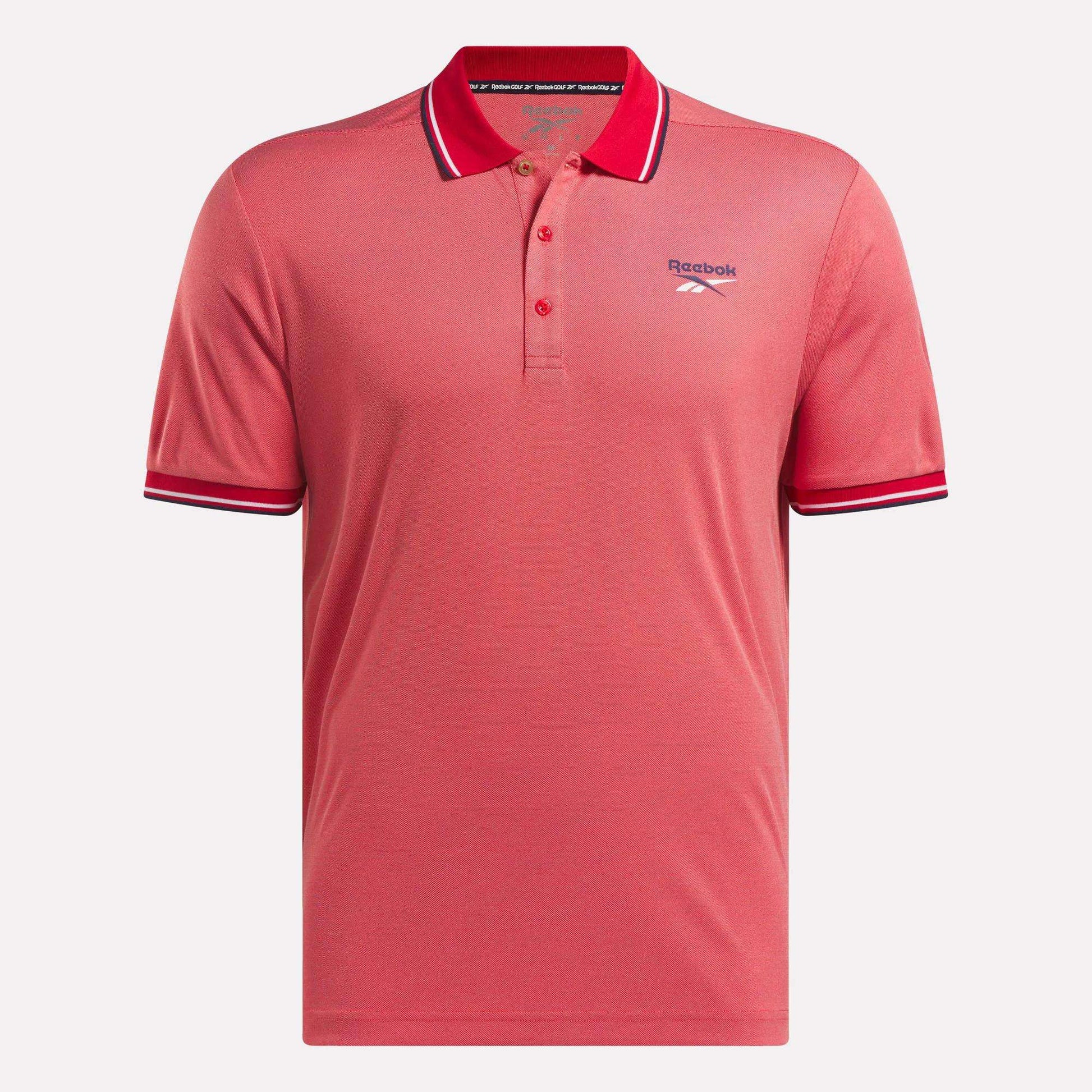 The Men's Country Club Oxford Pique Polo Shirt by Reebok is coral pink with a collar, three buttons, white and navy striped collar and sleeve cuffs, and an embroidered Reebok logo on the left chest.