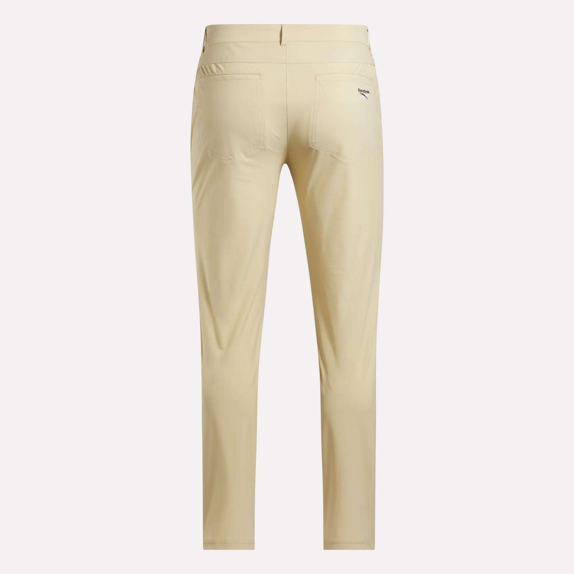 Back view of Reebok Men's Favorite 5-Pocket Relaxed Fit Golf Pants in light beige with RBK-DRY tech, two back pockets, and a small logo on the right pocket, displayed against a plain white background.