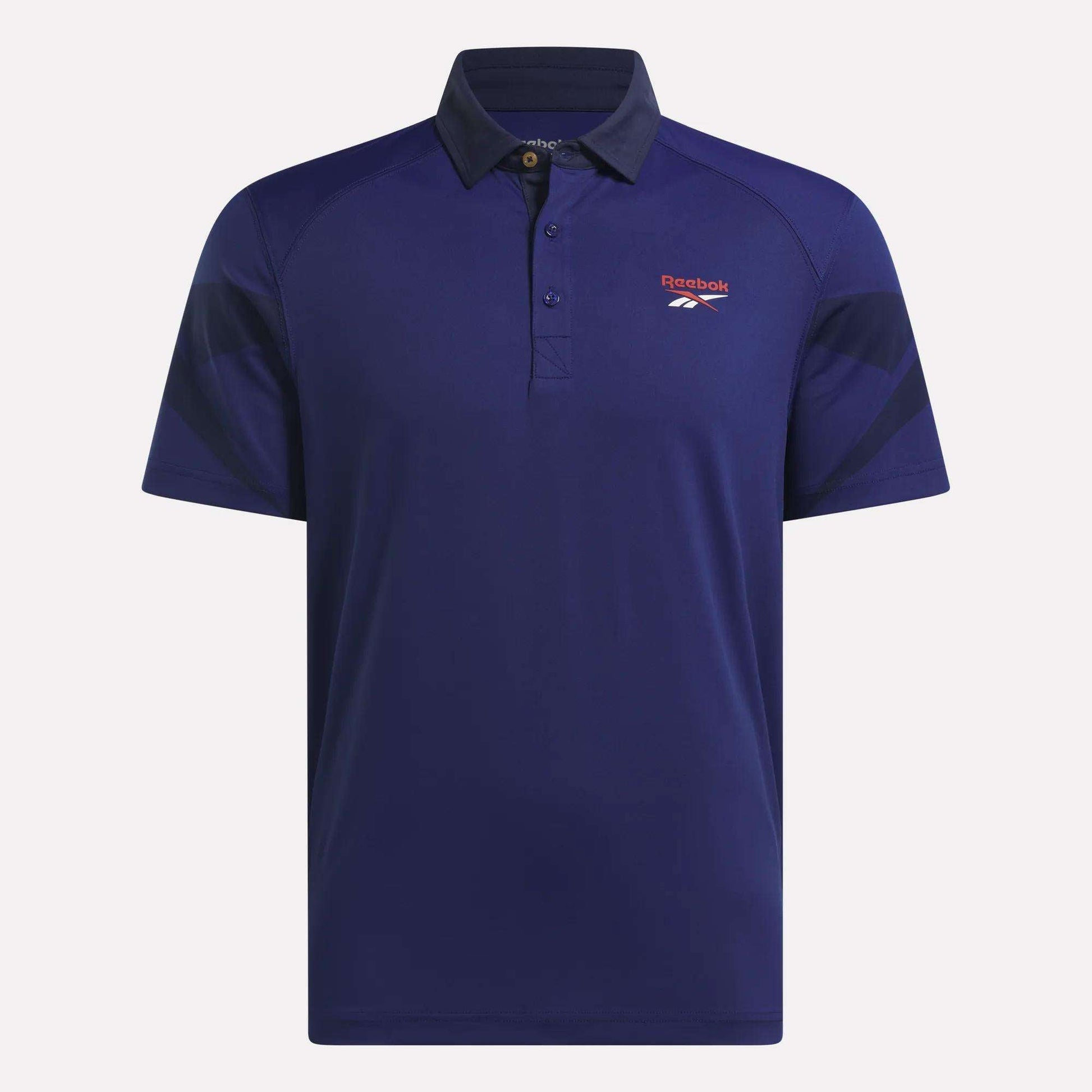 The Reebok Men's Signature Vector Colorblocked Polo Shirt is a dark blue, short-sleeve golf polo with black sleeve accents, a button-up collar, UPF 30+ sun protection, and moisture-wicking fabric. Red and white Reebok logo on the left chest.