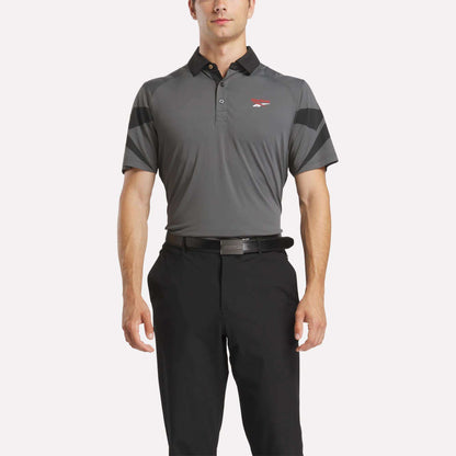 A man wearing a grey Reebok Men's Signature Vector Colorblocked Polo Shirt.