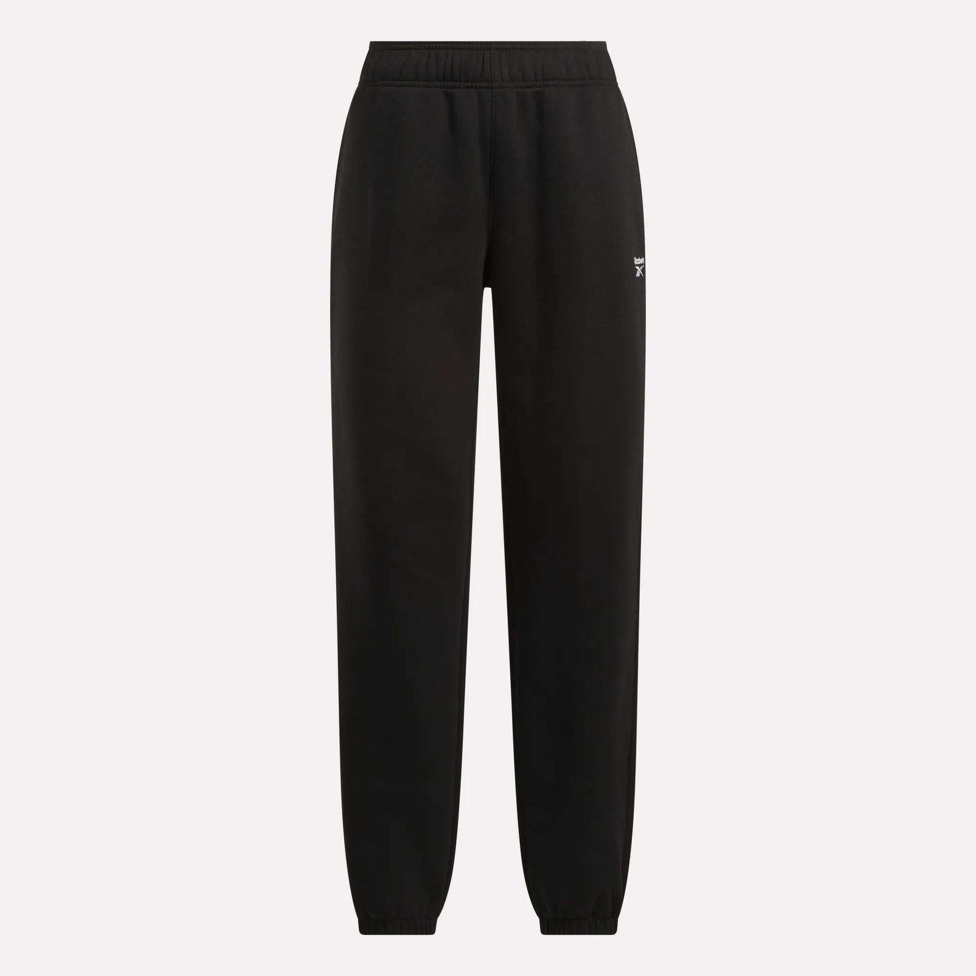 Reebok Women's Medium Vector Sweatpants in black with an elastic waistband and cuffed ankles, shown on a plain light background. Crafted from soft cotton-blend fabric with a small white Reebok logo on the upper left thigh.