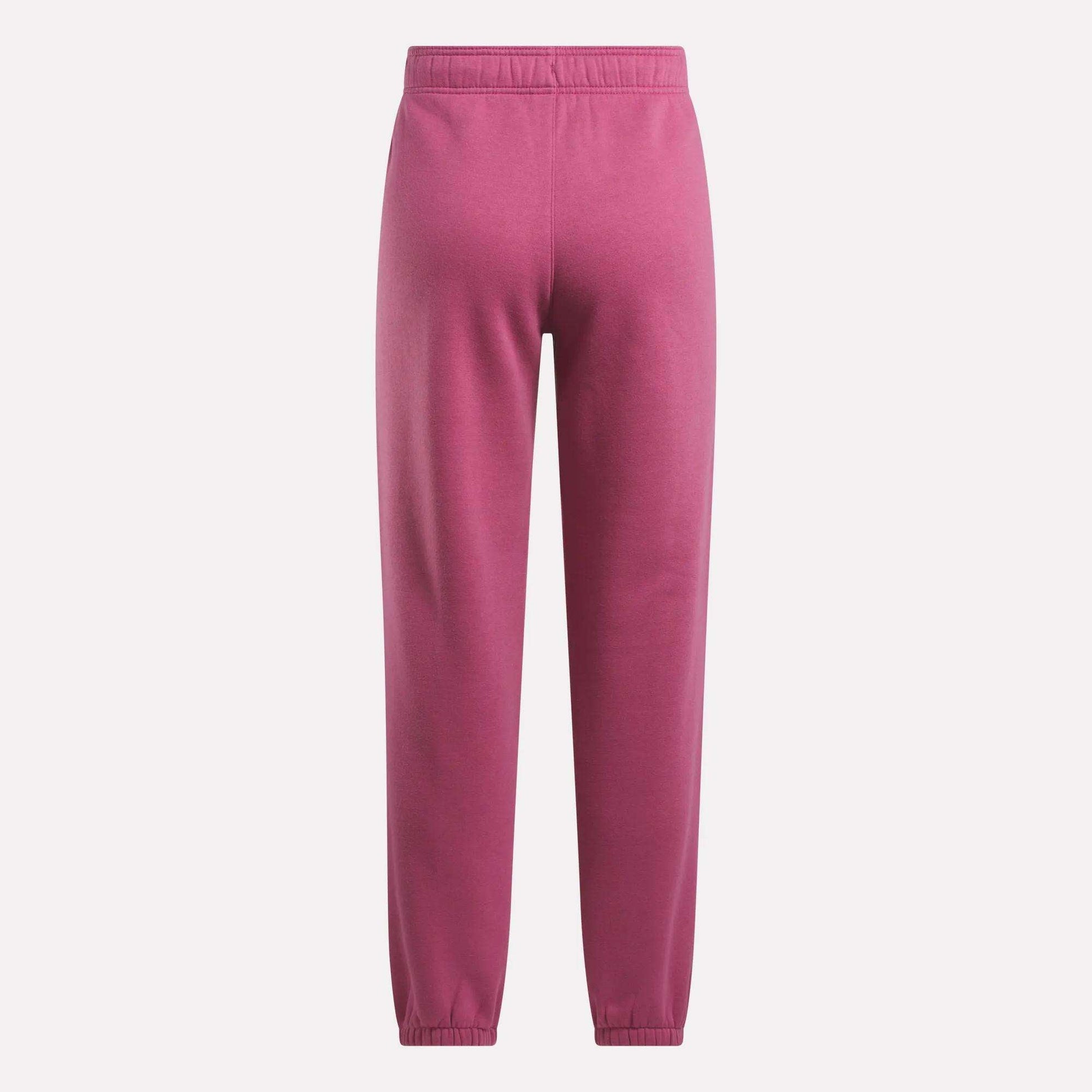 Reebok Women's Medium Vector Sweatpants in pink, made from a cotton blend with an elastic waistband and cuffs. These sweatpants offer a relaxed fit with no visible patterns or logos, shown against a plain white background.
