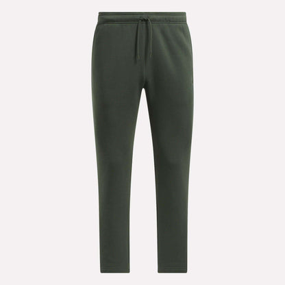 Men's Patent Pants by Reebok in dark green, with adjustable waistband and drawstring, slim fit tapered legs, shown on a plain light background.