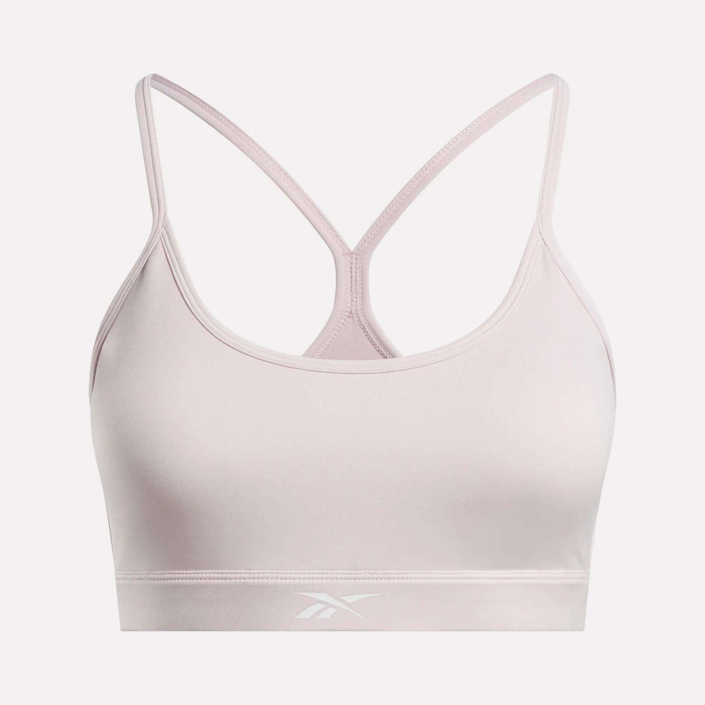 The Women's Strappy Sports Bra by Reebok features a light pink color, thin racerback straps, and a subtle front logo on the band. Made from smooth, stretchy quick-drying fabric, it delivers comfort and support for medium-impact workouts.
