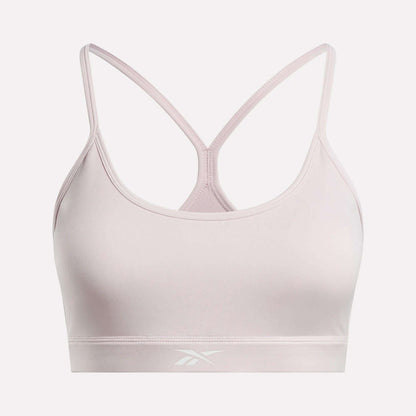 The Women's Strappy Sports Bra by Reebok features a light pink color, thin racerback straps, and a subtle front logo on the band. Made from smooth, stretchy quick-drying fabric, it delivers comfort and support for medium-impact workouts.