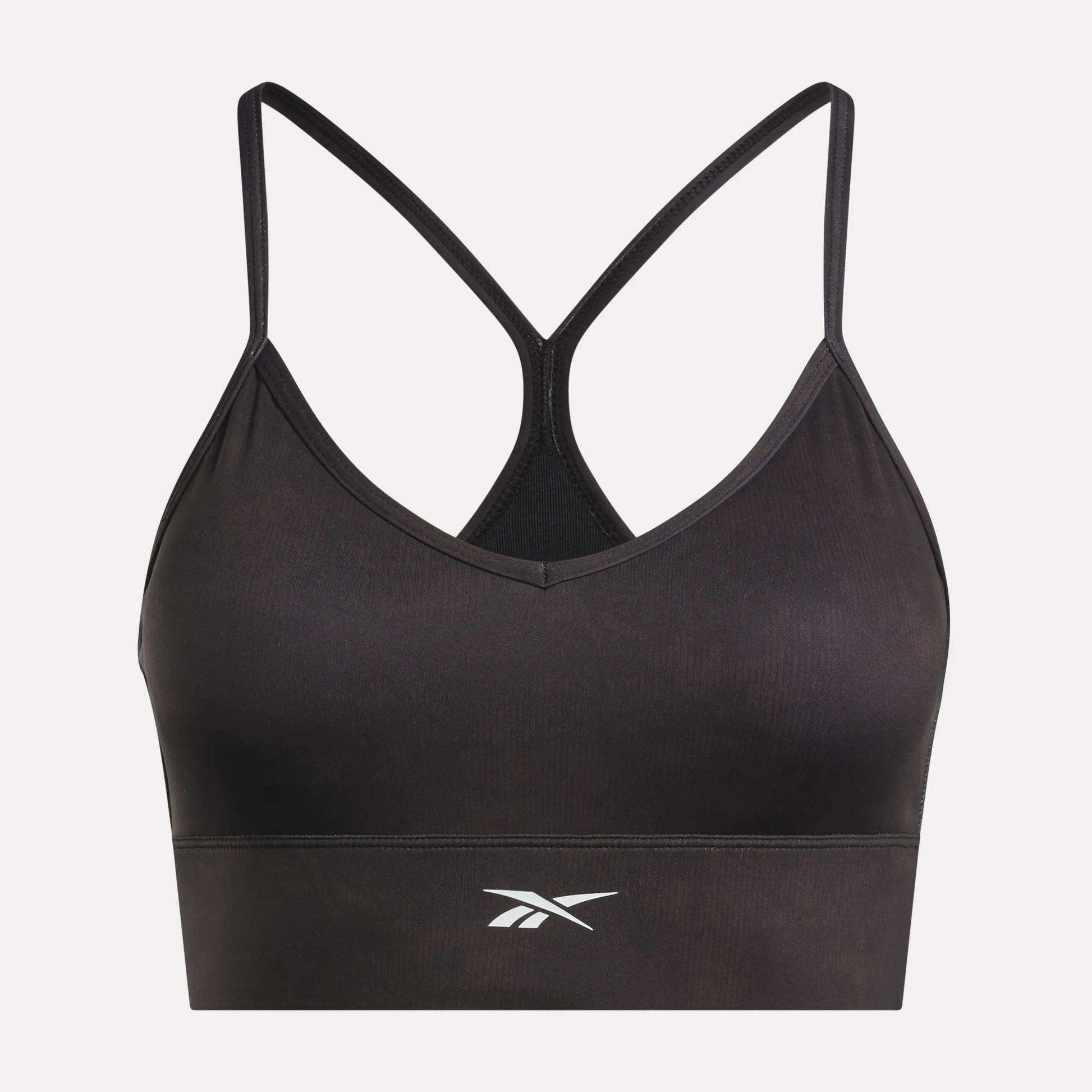 The Reebok Women's Printed Tri-Back Sports Bra features thin racerback straps and a white Reebok logo on the front, shown against a plain white background. Designed with sweat-wicking fabric, this workout bra keeps you comfortable and dry during your most intense sessions.