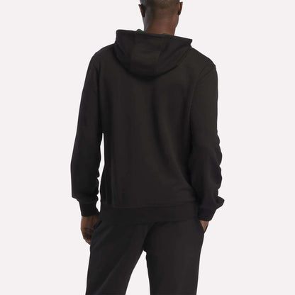 A person is shown from the back, standing against a plain, light background, wearing the Reebok Men's French Terry Hoodie and black pants.