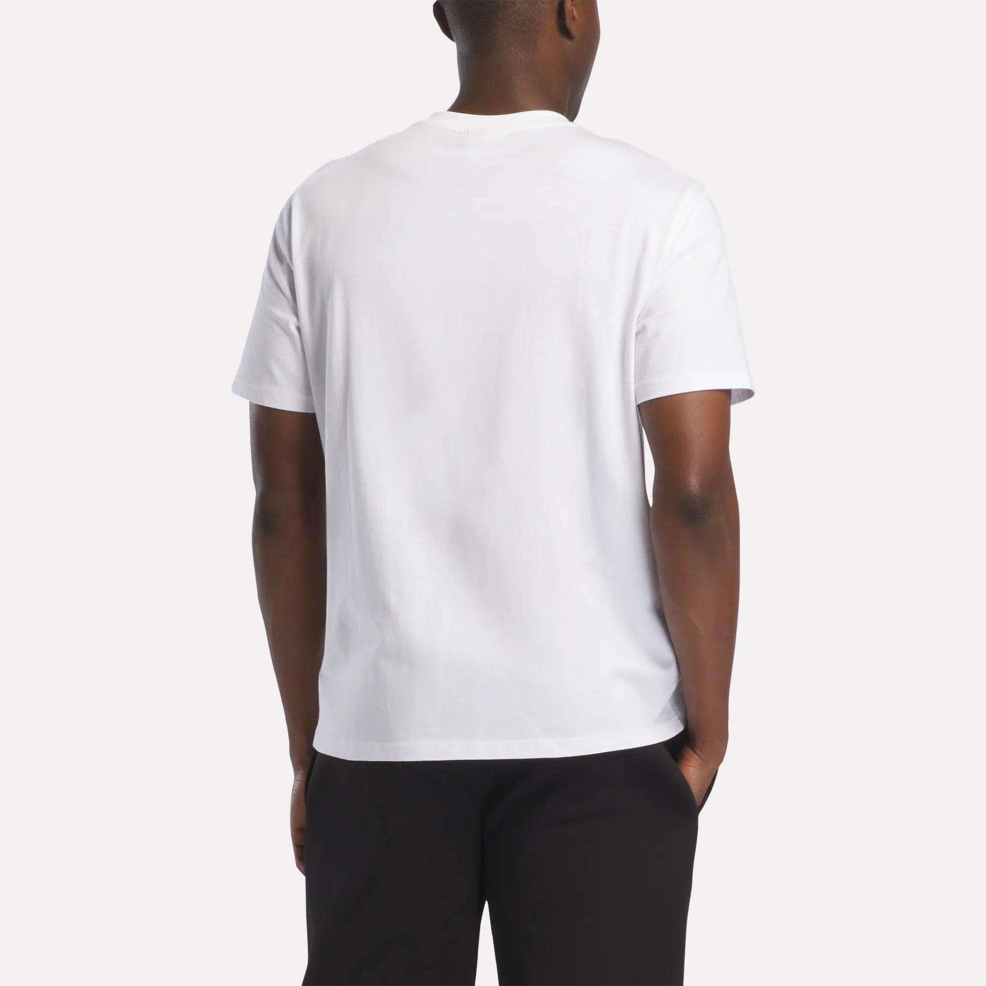 A person wearing a Reebok Men's Logo T-Shirt in white and black pants, shown from the back against a light background—perfect for everyday wear.