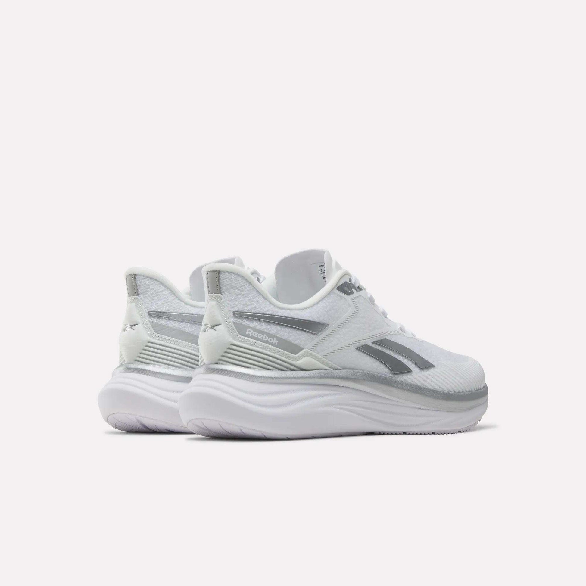 A pair of Reebok Women's Viva Speed Shoes in white with gray accents and a thick, cushioned midsole, positioned at an angle on a plain white background.