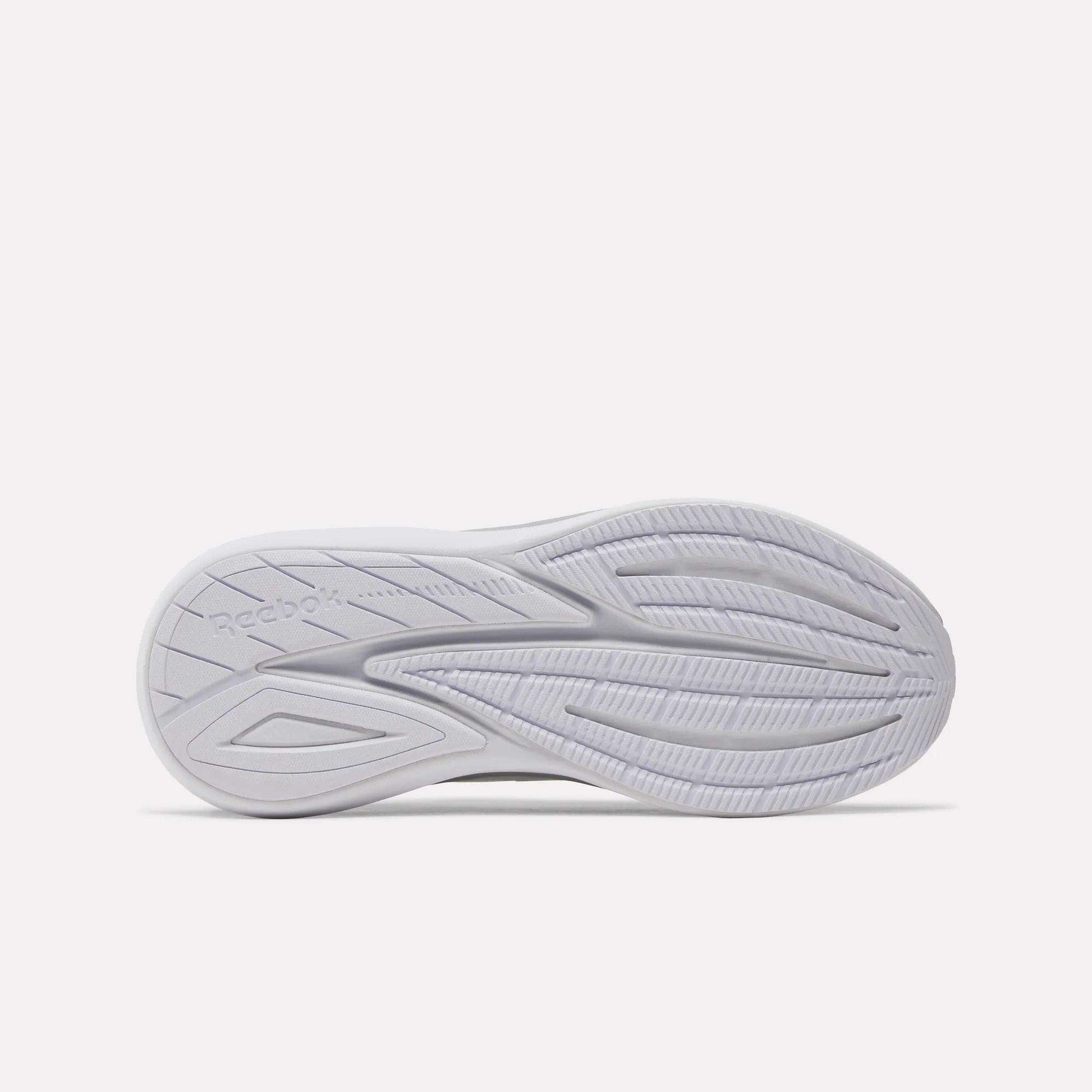 The image shows the bottom view of a white Women's Viva Speed Shoe sole by Reebok, featuring curved grooves and traction patterns, along with a cushioned midsole designed for all-day comfort and breathability.