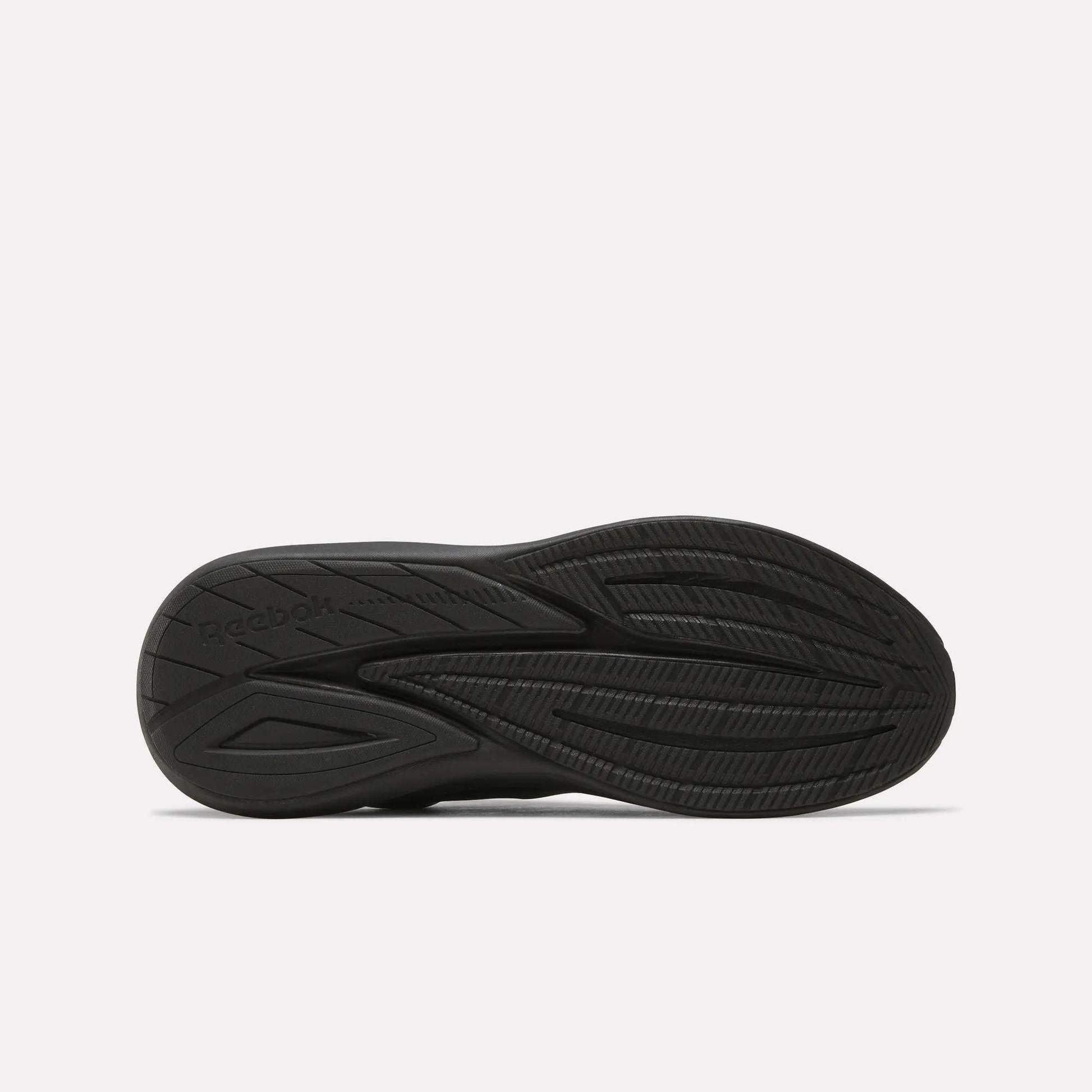 The image displays the black rubber outsole of Men's Viva Speed Shoes by Reebok, highlighting textured grooves and patterns for traction, set against a plain white background.