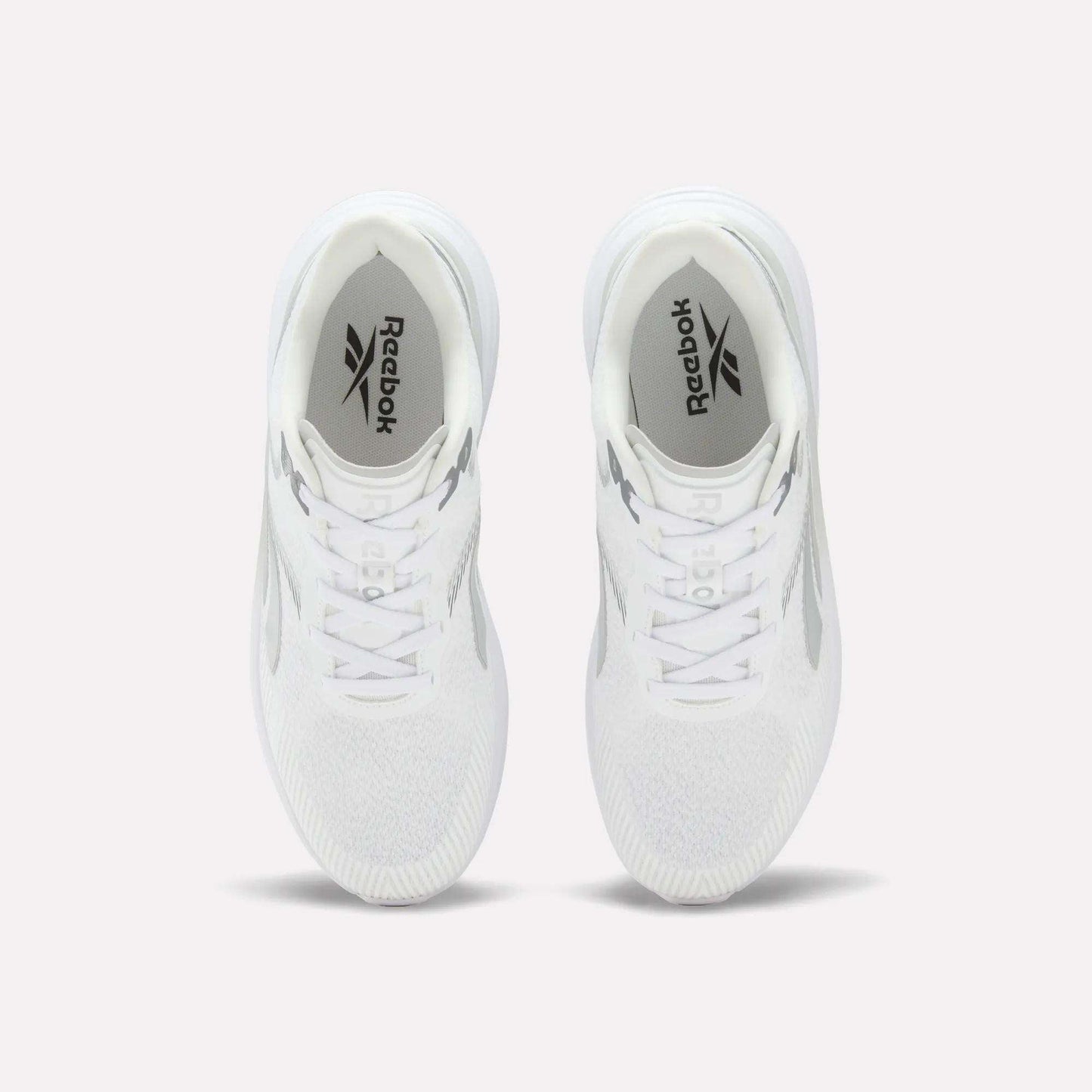 A pair of Men’s Viva Speed Shoes by Reebok in white is displayed from above on a light background, highlighting the Reebok logo on the insoles and the mesh uppers for enhanced breathability.