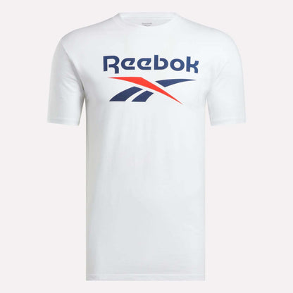 The Men’s Stacked Vector T-Shirt by Reebok is a classic white cotton tee with short sleeves, featuring the blue and red Reebok logo and brand name on the chest, shown against a plain light background.