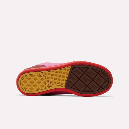 The image shows the sole of the Reebok x BBC Board Flip Skate Shoes, featuring a mix of brown, yellow, and red with a textured pattern. The shoe is on its side, sole up, against a plain white background—a bold nod to street style from Reebok.