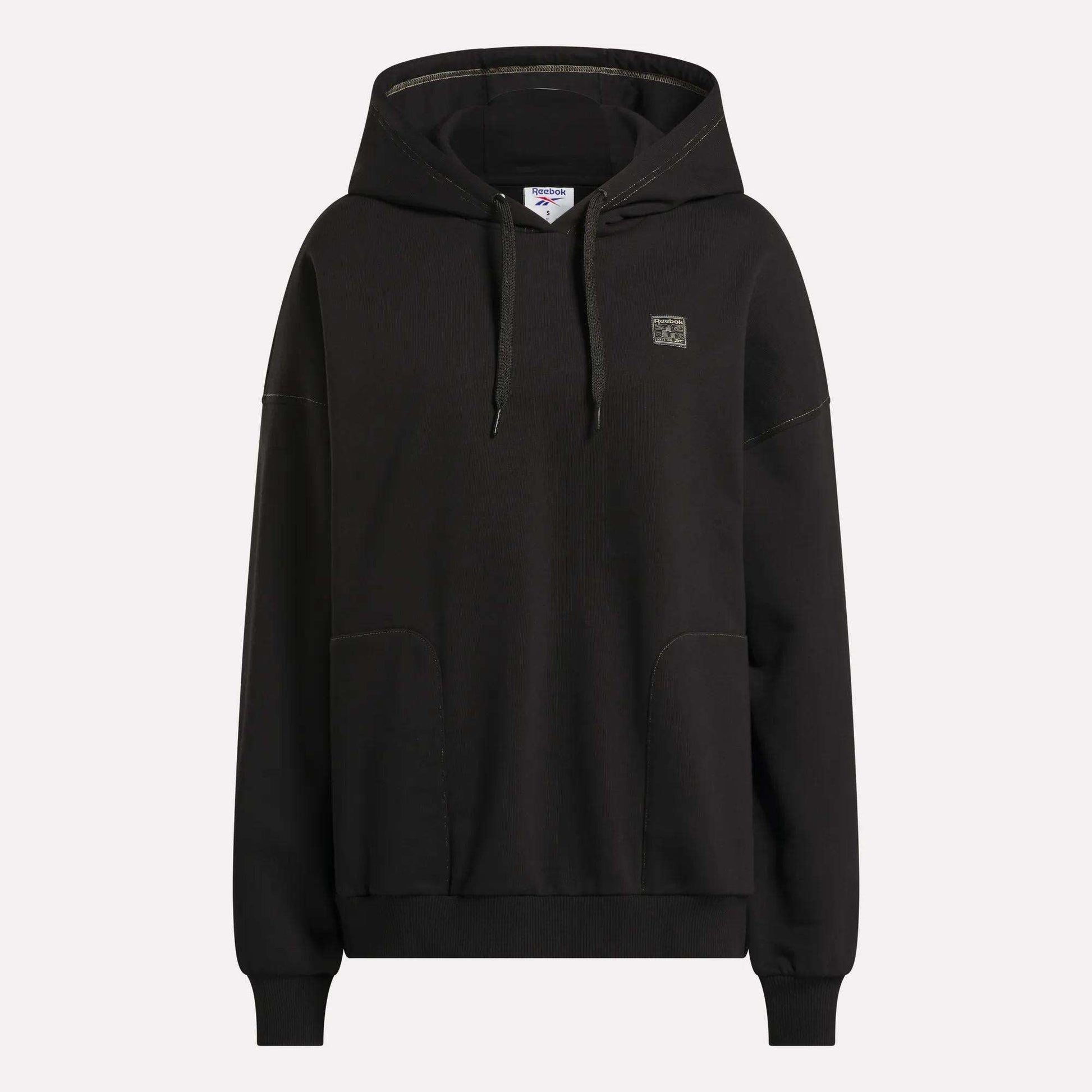 The Women's Relaxed Fleece Hoodie by Reebok is shown against a plain white background. This black hoodie features a front pocket, adjustable drawstrings, and a small square Reebok logo on the left chest.