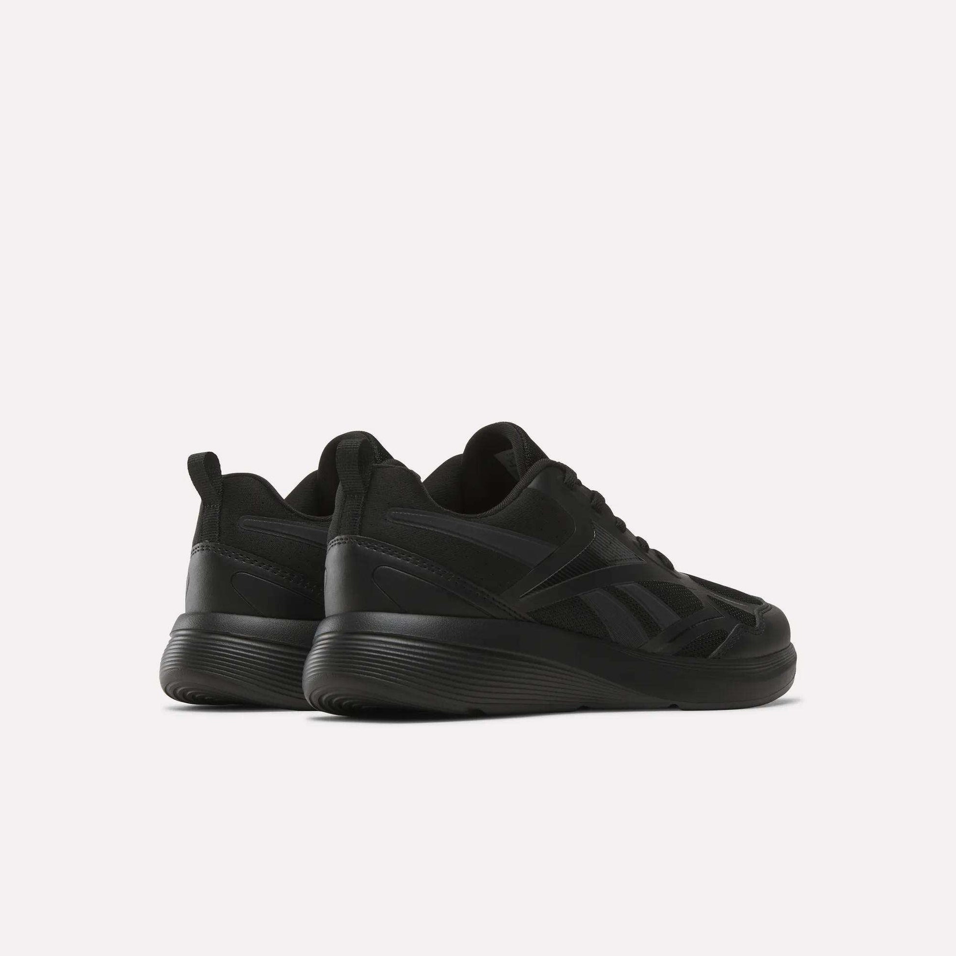 The Rush Runner 6.0 Running Shoes for big kids by Reebok are shown in black, featuring thick EVA midsoles, set against a white background and angled to display both the back and side views.