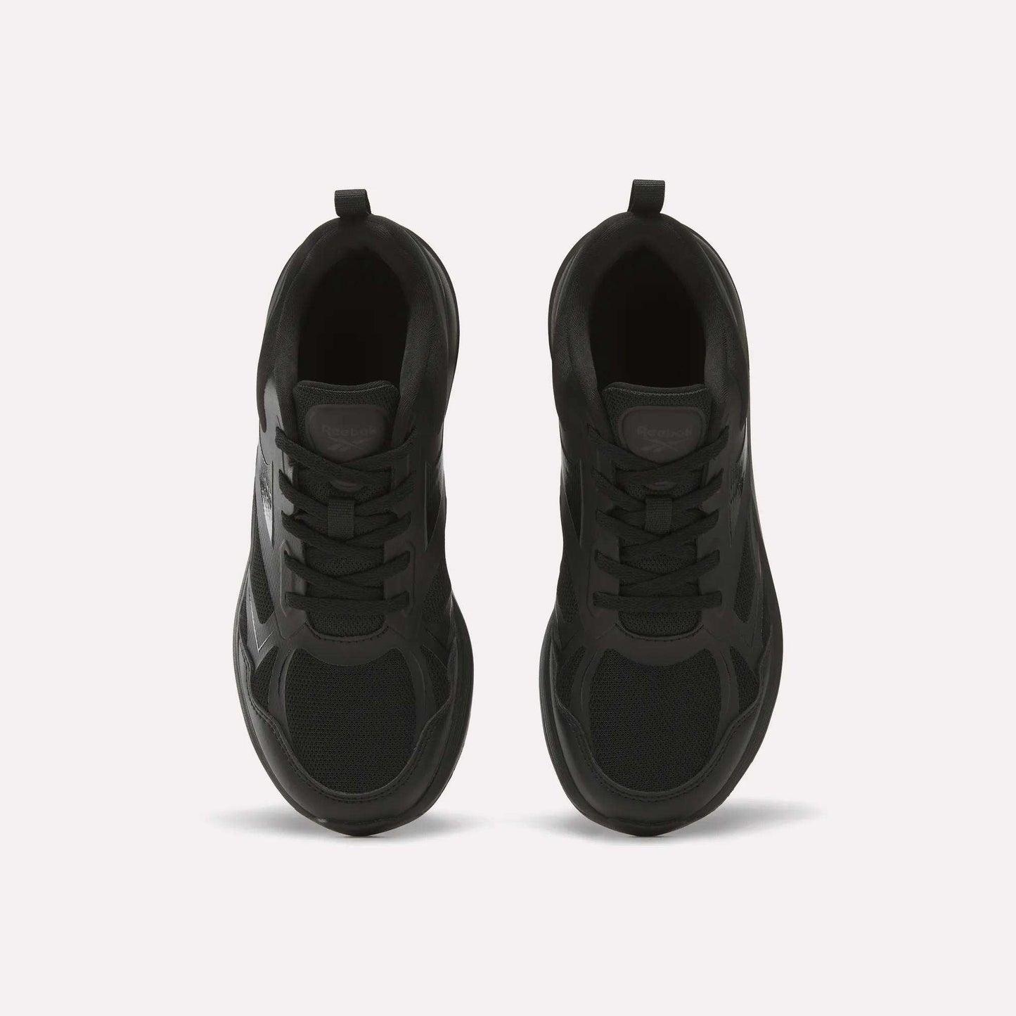 Top view of Reebok Rush Runner 6.0 Running Shoes for Big Kids, black with mesh and synthetic panels, black laces, EVA midsole, and heel pull tabs, placed side by side on a light background.