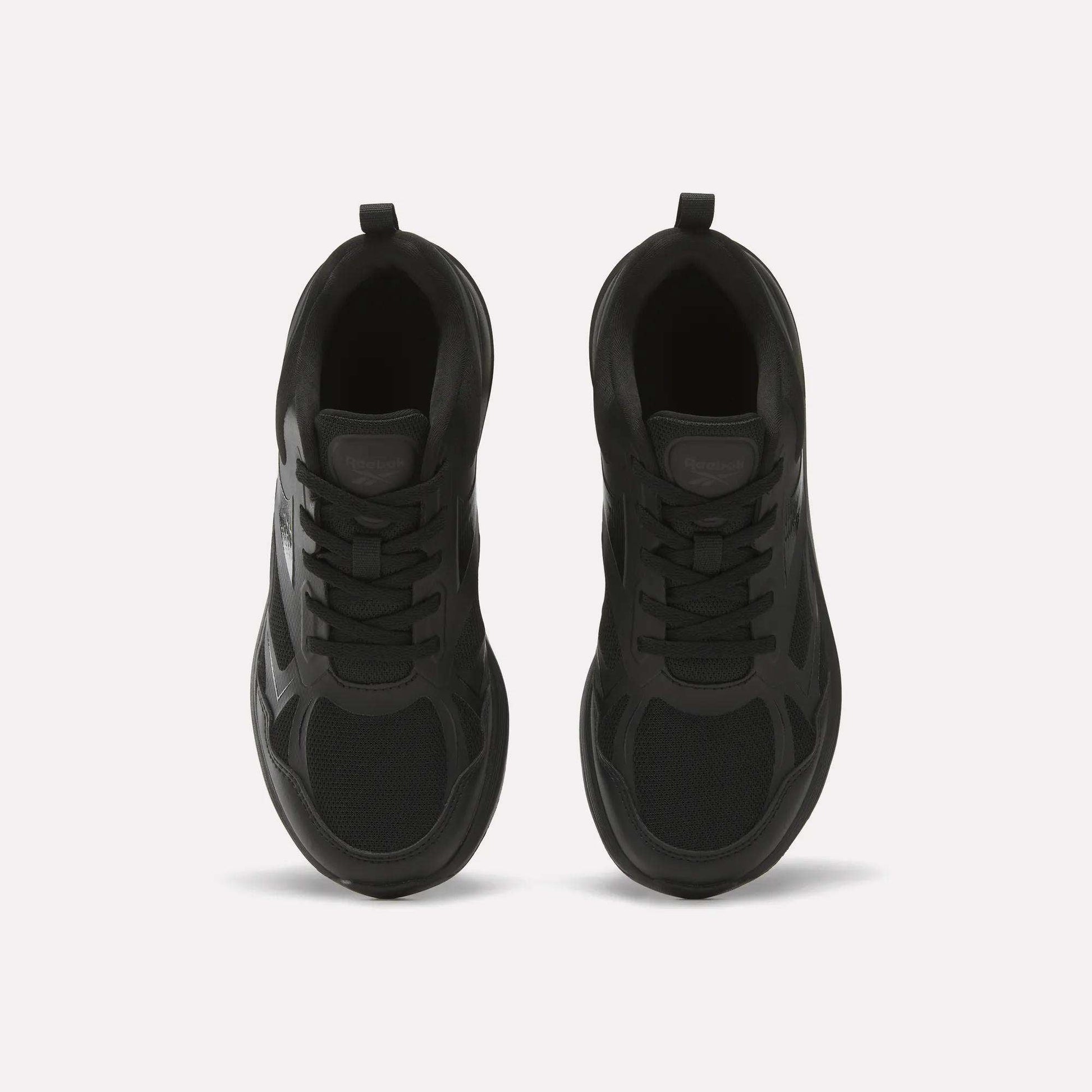 Top view of Reebok Rush Runner 6.0 Running Shoes for Big Kids, black with mesh and synthetic panels, black laces, EVA midsole, and heel pull tabs, placed side by side on a light background.
