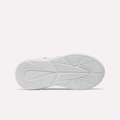 Bottom view of the Rush Runner 6.0 Elastic Lace Top Strap Running Shoes for little kids by Reebok, showing a white rubber sole with geometric tread patterns and a subtle logo on the heel, inspired by classic Reebok designs against a plain light background.