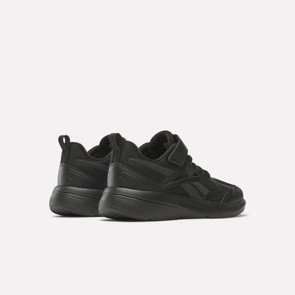 A pair of black Reebok Rush Runner 6.0 Elastic Lace Top Strap Running Shoes for little kids, shown from a rear-side angle on a light background. These low-top shoes have thick soles and subtle panel details, ideal for all-day play.