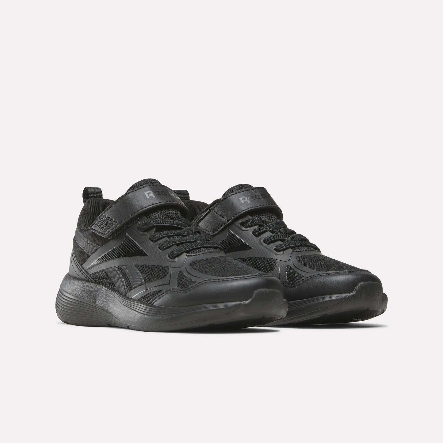 The Reebok Rush Runner 6.0 Elastic Lace Top Strap Running Shoes for little kids feature a black design with Velcro and laces, a textured sole, and subtle details—perfect for all-day play, shown against a plain light background.