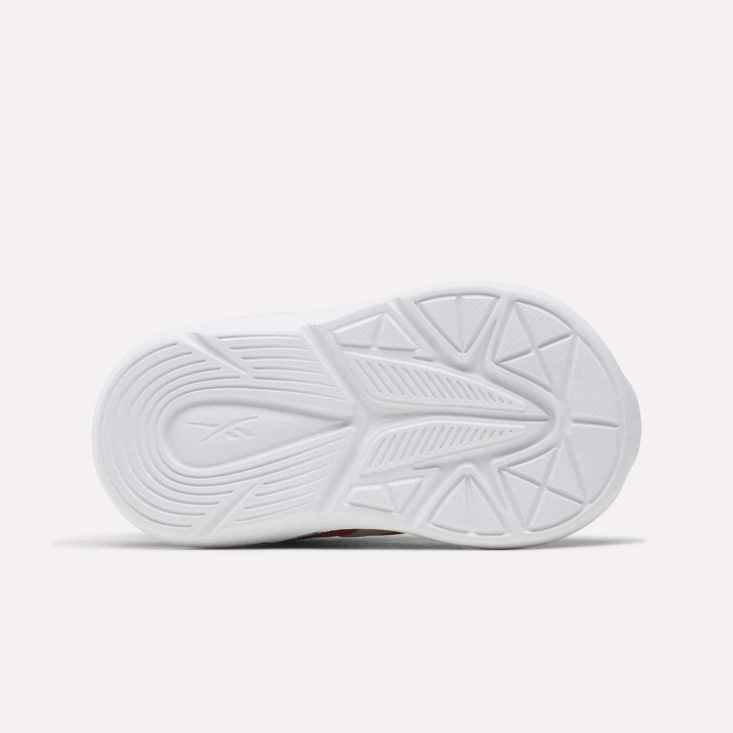 The image features the white sole of Reebok Rush Runner 6.0 Gore Lace Top Strap Running Shoes for babies and toddlers, with a geometric tread pattern, subtle center branding, and lightweight EVA cushioning, shown against a plain light background.