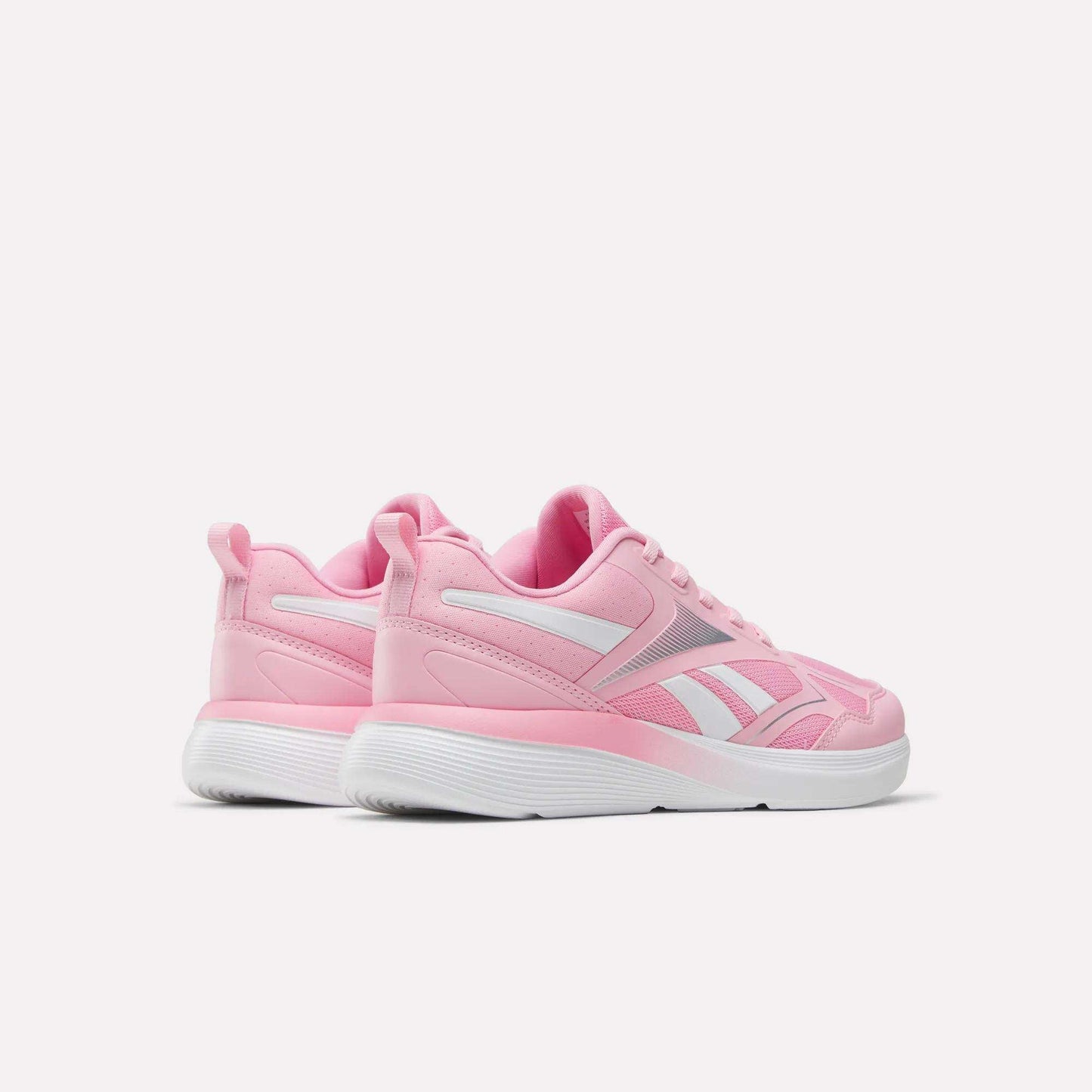 A pair of Reebok Rush Runner 6.0 Running Shoes for big kids in pink and white with white EVA midsoles, shown from the back and side on a plain white background.