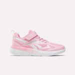 The Reebok Rush Runner 6.0 Elastic Lace Top Strap Running Shoes for little kids in Expressive Pink/Ftwr White feature a mesh and synthetic upper, hook-and-loop strap, elastic laces, and a white sole, shown in side profile on a white background.