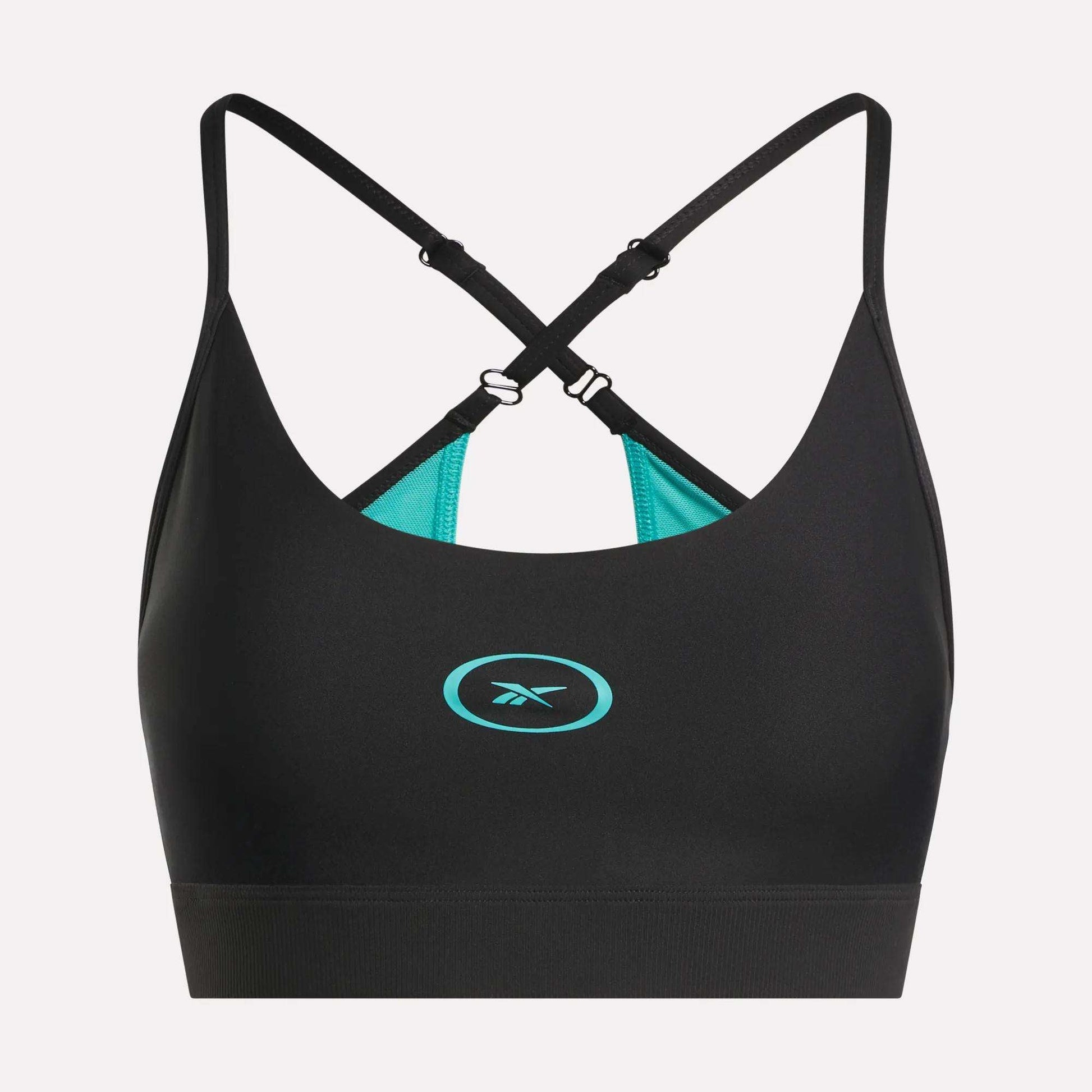 The Reebok Women's Speed Strappy Sports Bra features a black design with adjustable criss-cross straps, turquoise inner lining, and a turquoise Reebok logo on the front center, displayed on a plain light background.