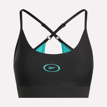 The Reebok Women's Speed Strappy Sports Bra features a black design with adjustable criss-cross straps, turquoise inner lining, and a turquoise Reebok logo on the front center, displayed on a plain light background.
