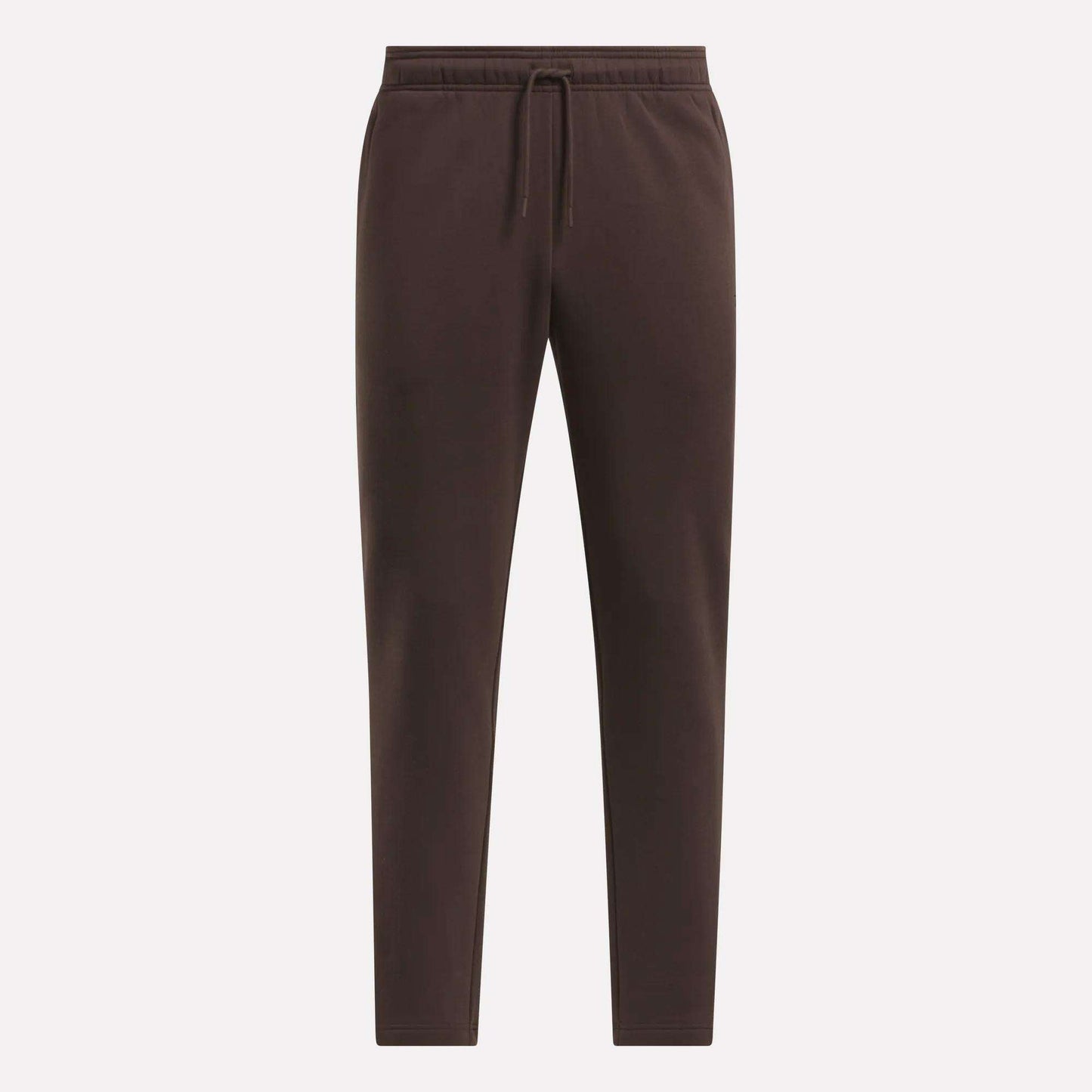 The Men's Patent Pants by Reebok are dark brown, slim fit joggers with an elastic waistband, drawstring, and tapered legs. Made from a soft cotton-poly blend, they are shown against a light background.