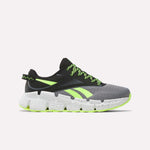 The Reebok Zig Dynamica 6 Running Shoes for big kids in Grey 4/Black/Digital Lime feature neon laces, black detailing, and a chunky speckled sole—engineered with Zig technology for superior running performance.