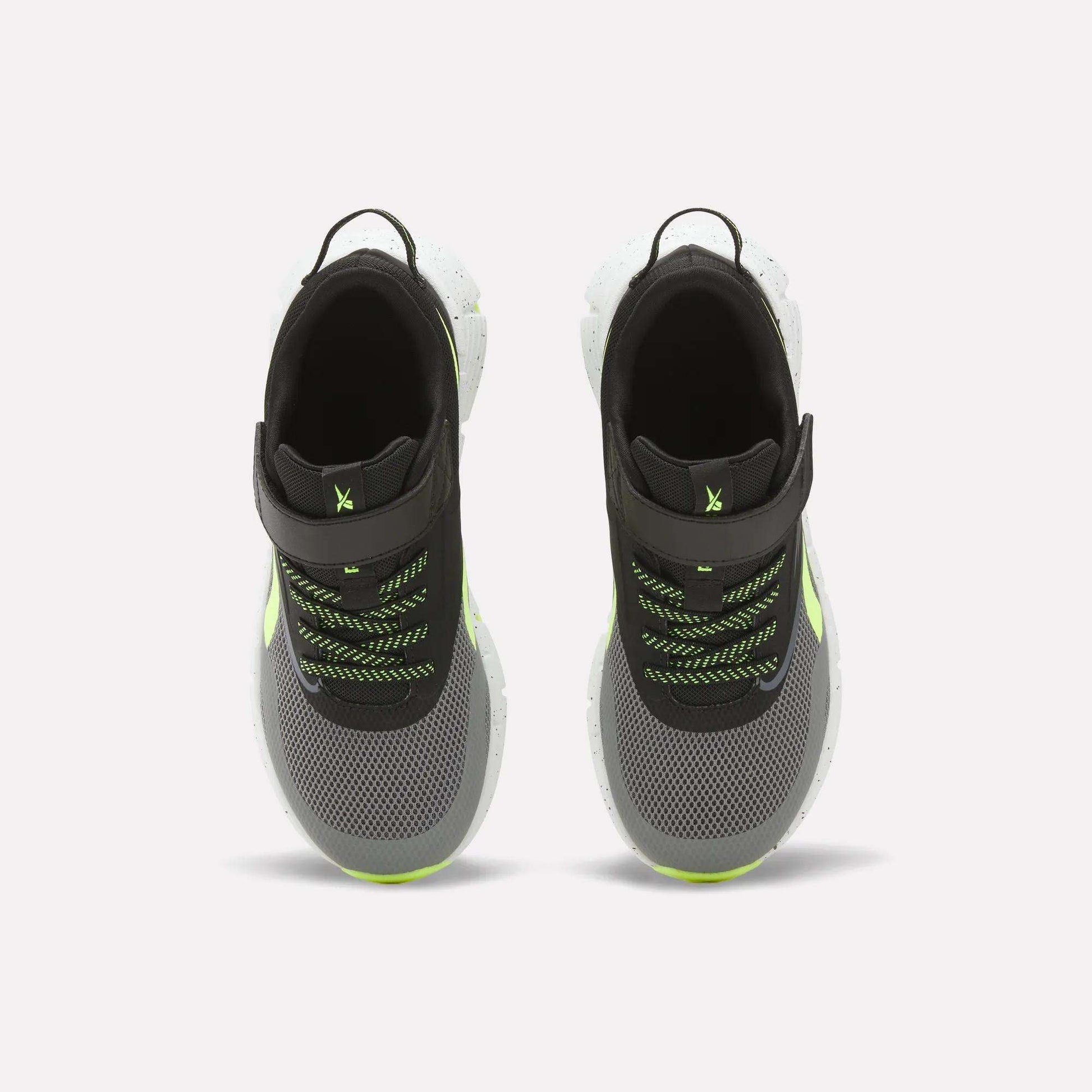 Top view of Reebok Zig Dynamica 6 Running Shoes for little kids in black and gray with neon green accents, white Zig soles, mesh uppers, black pull tabs, and green/black laces on a white background.