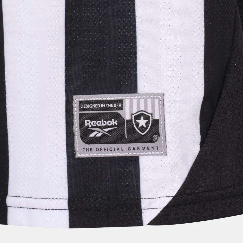Close-up of the Kids' Botafogo Youth Home Jersey by Reebok, featuring black and white stripes with a patch displaying the Reebok logo, a star, and text: Designed in the BFR and The Official Garment.