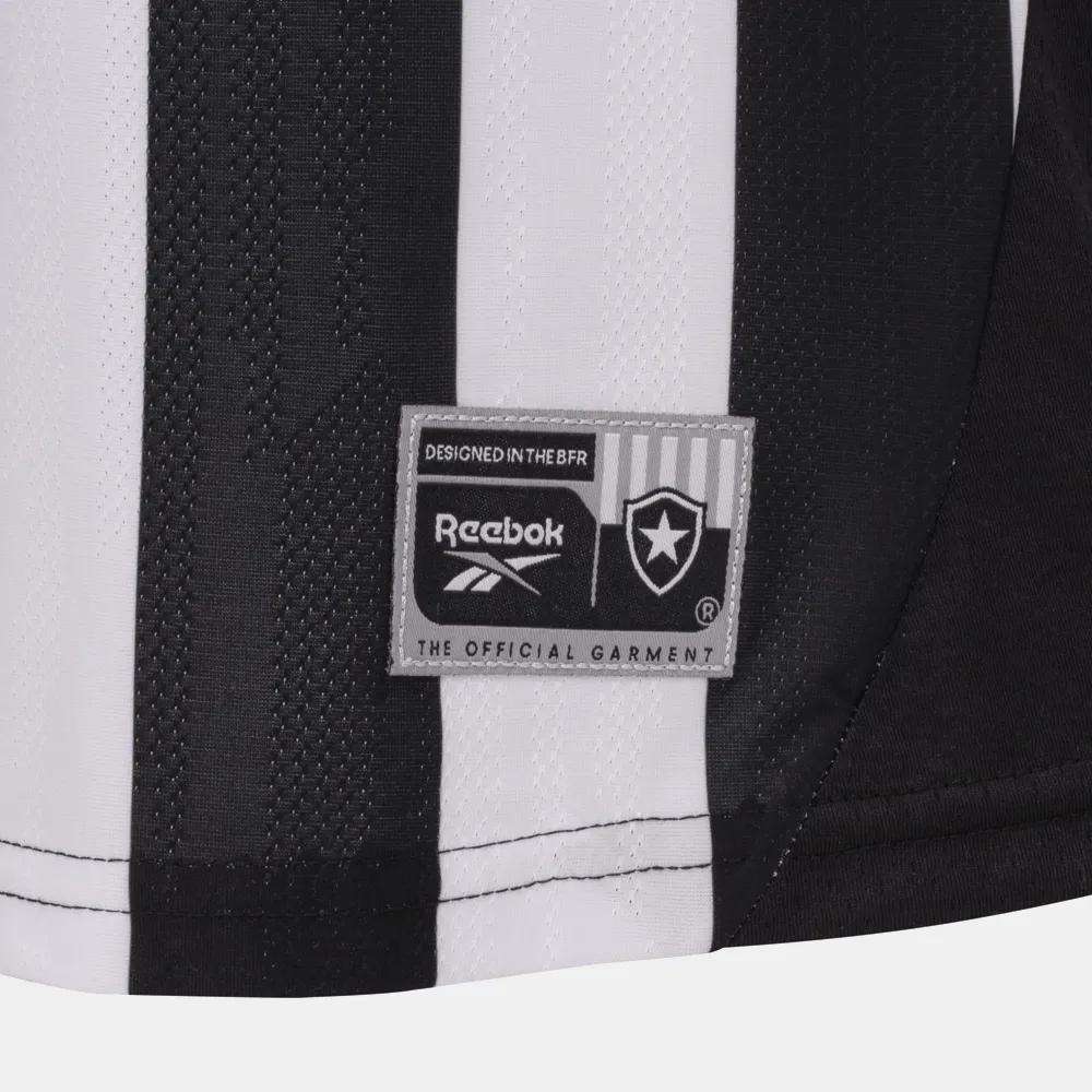 Close-up of the Botafogo Women's Home Jersey by Reebok, showcasing black and white stripes, a stitched Reebok label and badge, plus “DESIGNED IN THE BFR” and “THE OFFICIAL GARMENT”—a preview of the 25/26 football shirt.