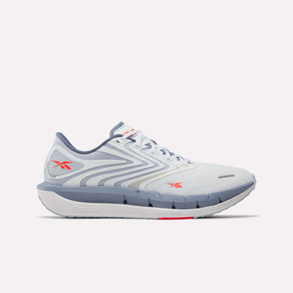 Side view of a white and light gray Reebok Men's FloatZig Tread Running Shoe with blue-gray sole and red logos. Mesh upper, cushioned midsole, and sleek design make it ideal for treadmill workouts or daily runs.