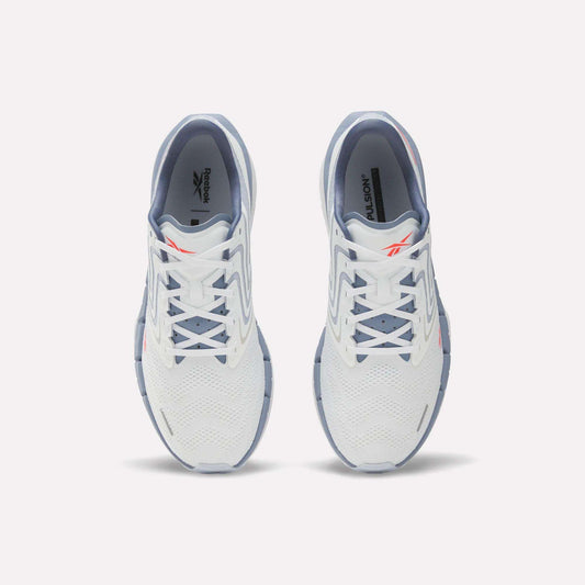 A pair of Reebok Men's FloatZig Tread Running Shoes in white with light blue accents viewed from above, highlighting the laces, mesh upper, and Reebok logo—perfect for treadmill workouts.