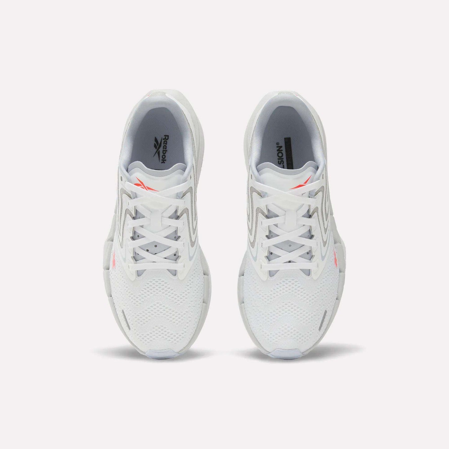 A pair of Women's FloatZig Tread Running Shoes by Reebok, viewed from above, with a breathable mesh upper, grey accents, and small orange Reebok logos on each tongue—perfect for treadmill workouts.
