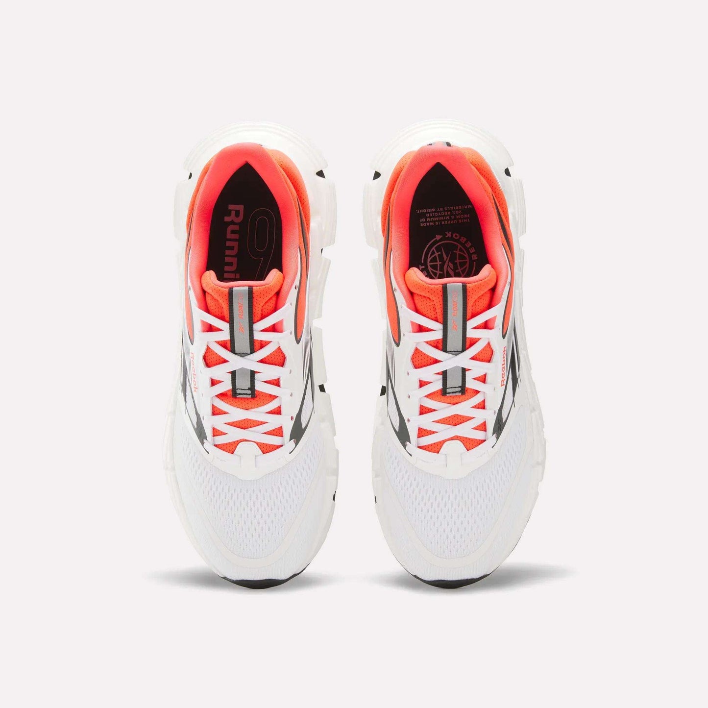 A pair of Reebok Men's FloatZig 2 Running Shoes with Superfloat+ cushioning, supportive white upper, orange inner lining, gray accents, and white laces is shown from above on a plain light background.