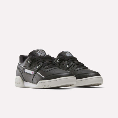 A pair of Reebok Workout Plus Shoes in black leather with white soles and subtle white accents, placed side by side on a plain, light background.