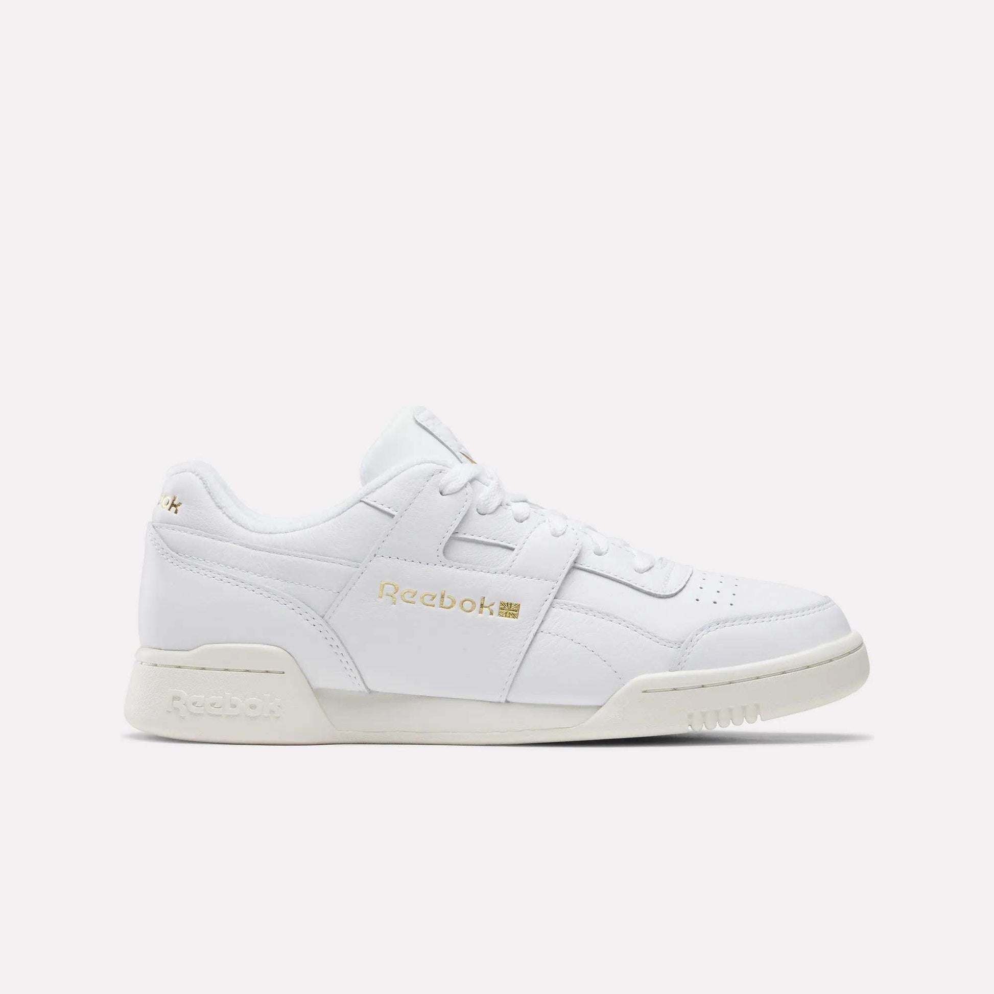 The Reebok Workout Plus Shoes in Chalk/Ftwrwhite/Goldmetallic feature a low-top design with white laces and gold branding, showcased on a plain light background—a true tribute to classic '80s fitness style.