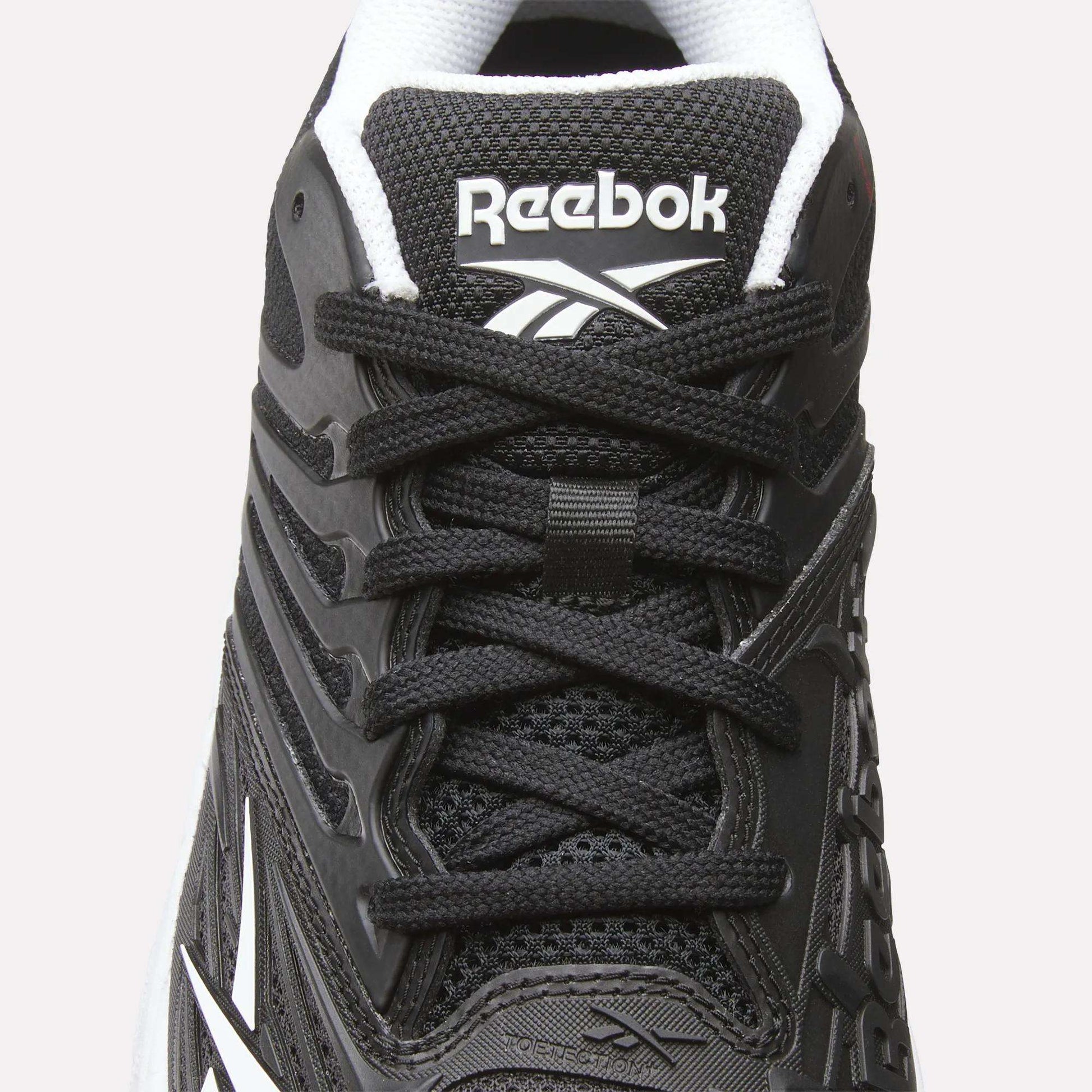 Close-up of the Women's Phase Evo Tennis Shoes by Reebok in black with white accents, featuring laces, mesh texture, side design, and the Reebok logo on the tongue.