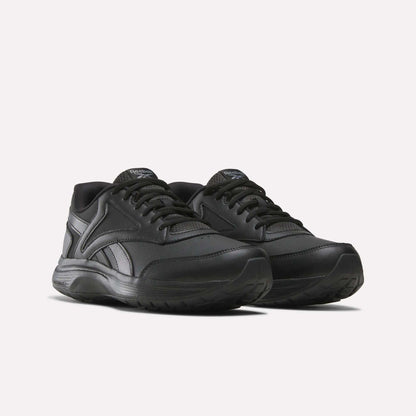 A pair of Men's Walk Ultra 7 DMX Max Shoes by Reebok in black, featuring matching black laces and soles with DMX cushioning for enhanced comfort, displayed on a white background and angled slightly to the left.