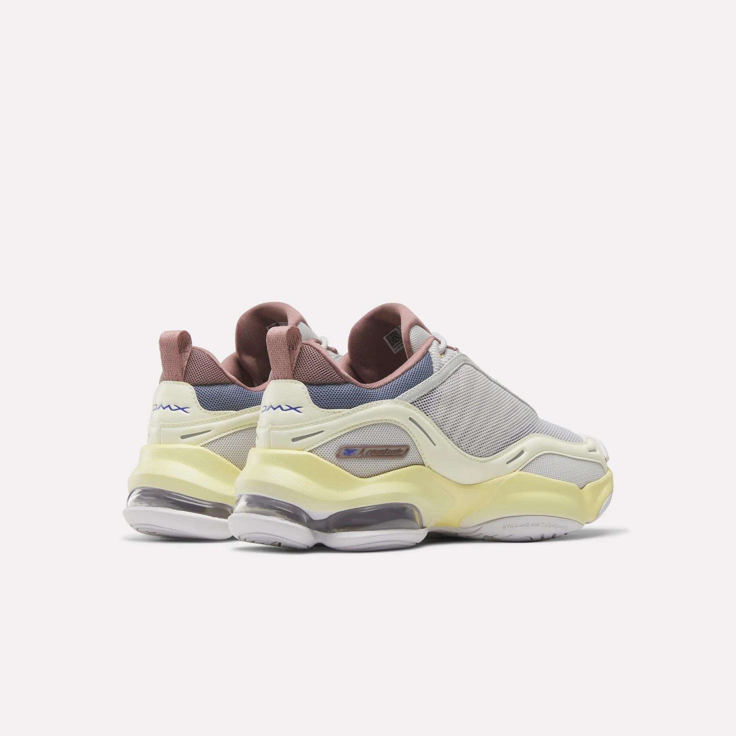 A pair of Reebok Women's DMX Series 3000 Training Shoes featuring light gray mesh uppers, yellow accents, pinkish-brown heel tabs, and transparent DMX 3 Technology sole cushioning, displayed against a plain white background.