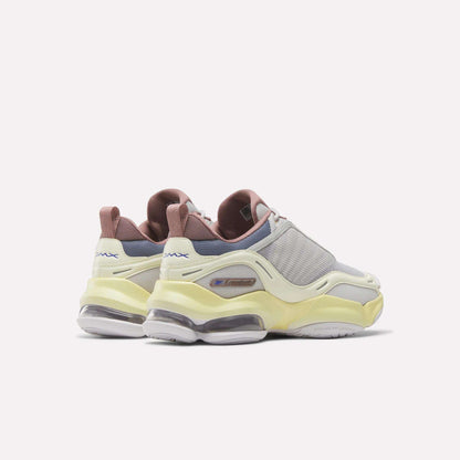A pair of Reebok Women's DMX Series 3000 Training Shoes featuring light gray mesh uppers, yellow accents, pinkish-brown heel tabs, and transparent DMX 3 Technology sole cushioning, displayed against a plain white background.